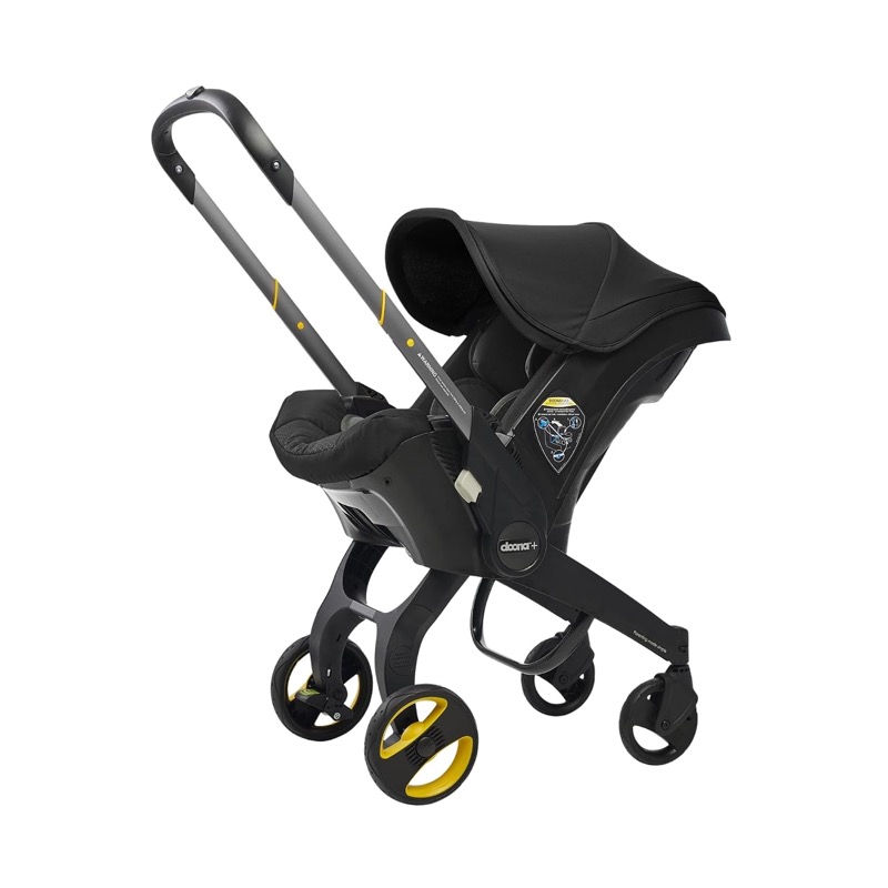 black doona infant car seat with built-in wheels unfolded into stroller mode with its handle raised