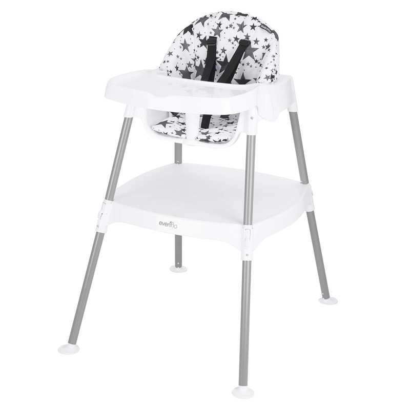 white evenflo eat and grow convertible high chair with a black and white star seat pad and a tray