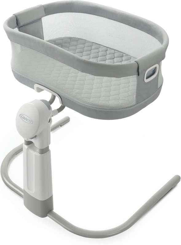 gray graco dreammore bedside bassinet with mesh sides on a curved stand