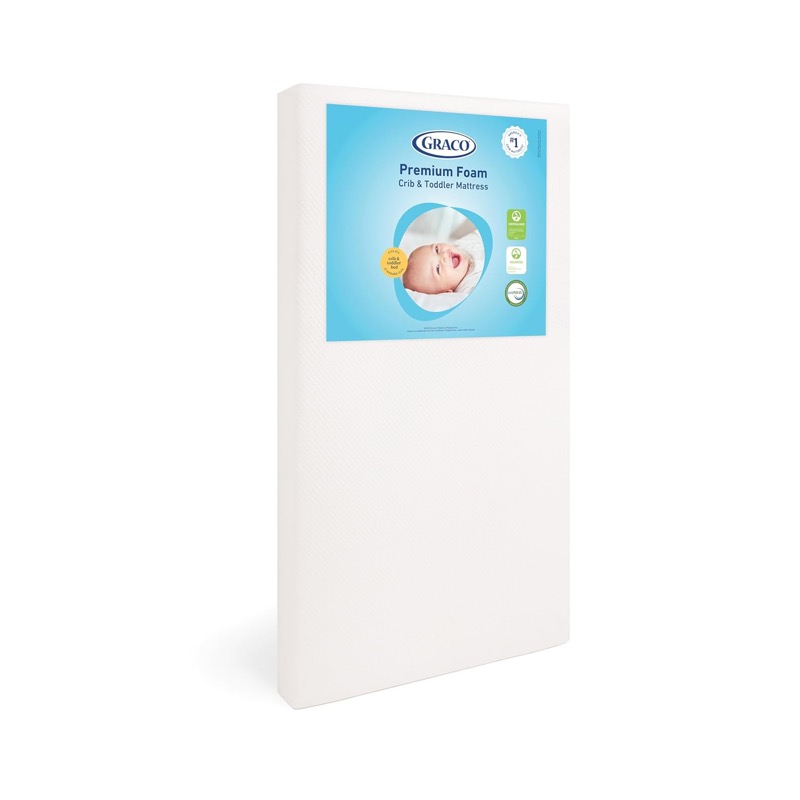 white graco premium foam crib mattress standing on its side with its label