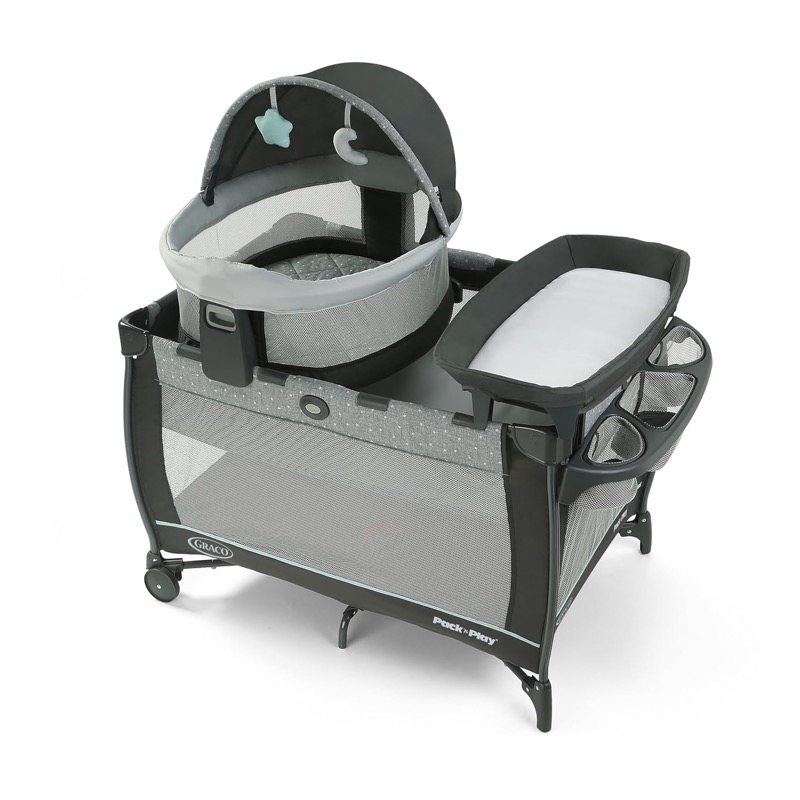 gray graco travel dome lx play yard with a raised dome bassinet and a diaper changer on top
