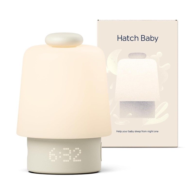 putty-colored hatch baby sound machine and night light glowing beside its box