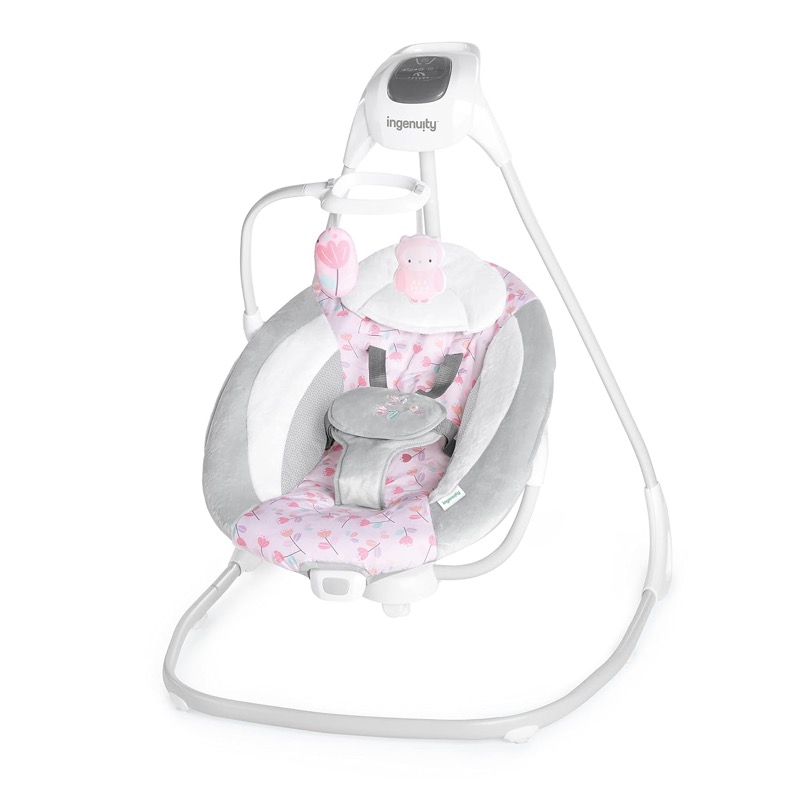 white and pink ingenuity simplecomfort baby swing with an overhead mobile and a large padded seat