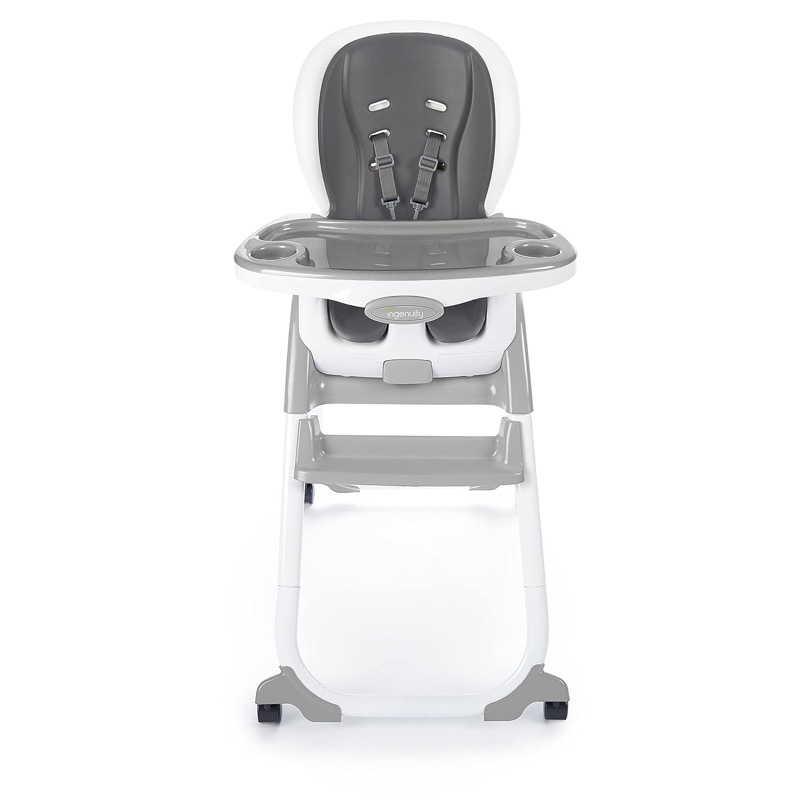 white and gray ingenuity smartclean trio elite high chair with a molded seat, harness and tray on wheels