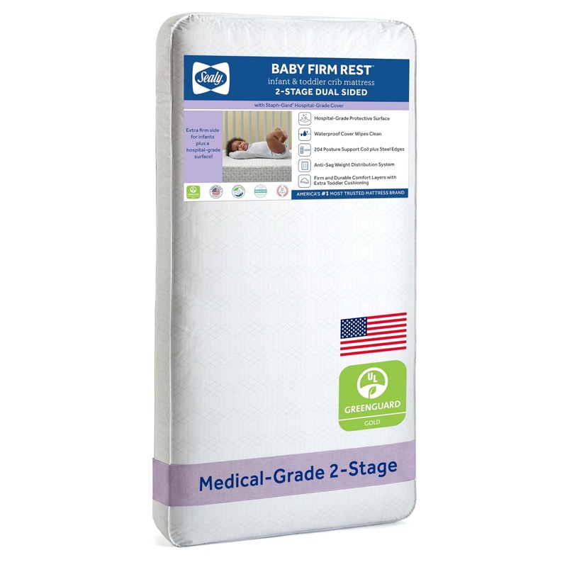 white sealy baby firm rest coil crib mattress with a blue label