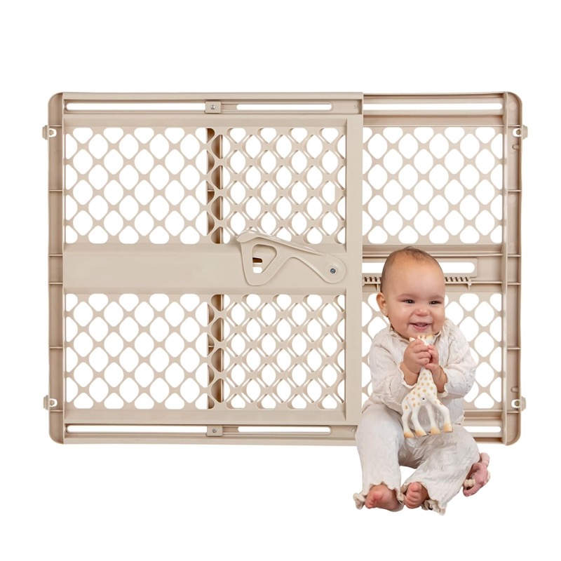 beige plastic toddleroo supergate ergo baby gate with a toddler standing behind it